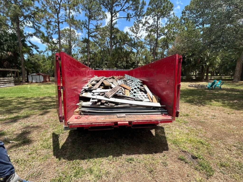 Construction debris from a deck removal project loaded into a dumpster in Palm Beach County, FL.