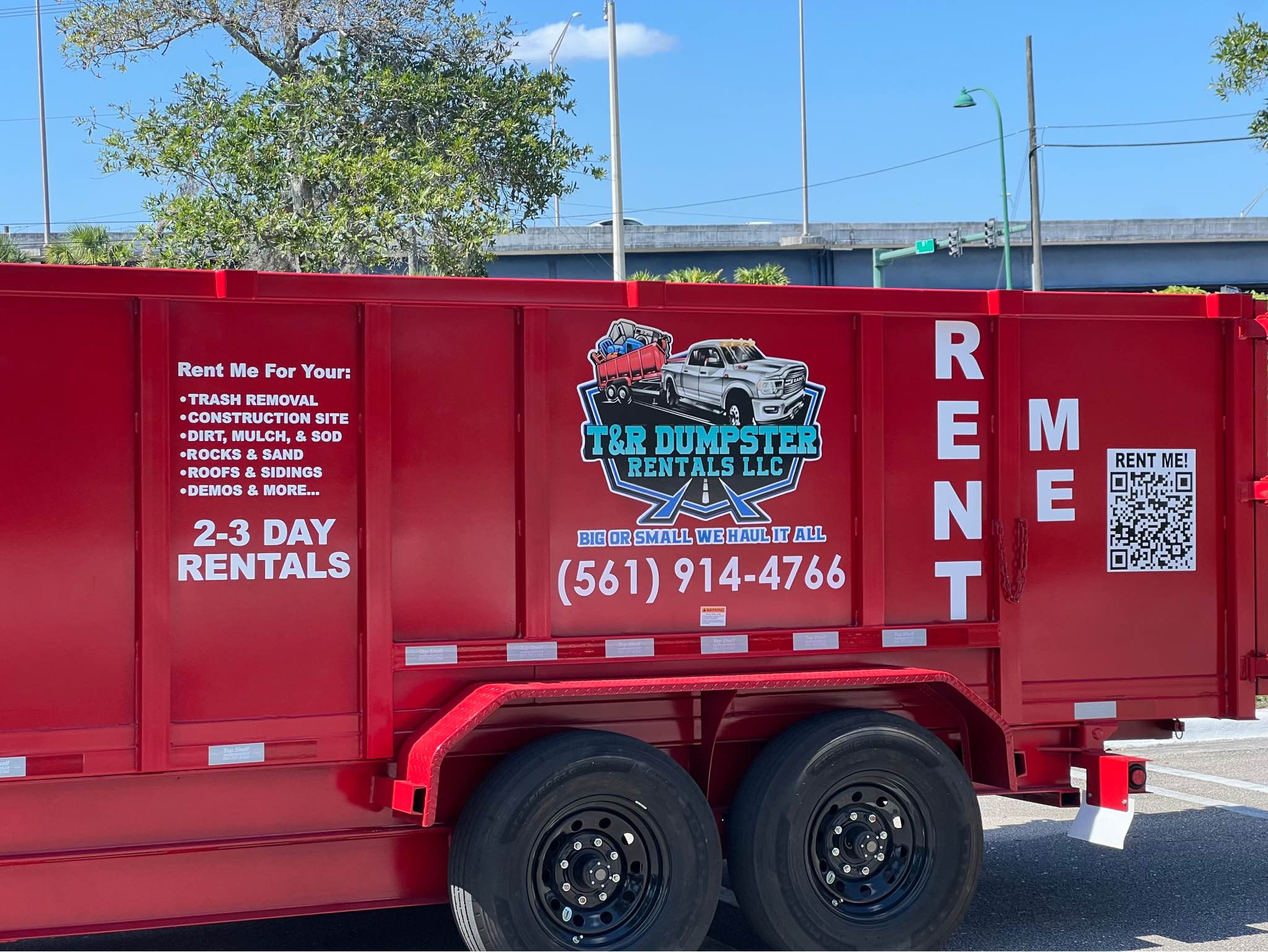Side view of a red 17-yard dump trailer parked in a parking lot.