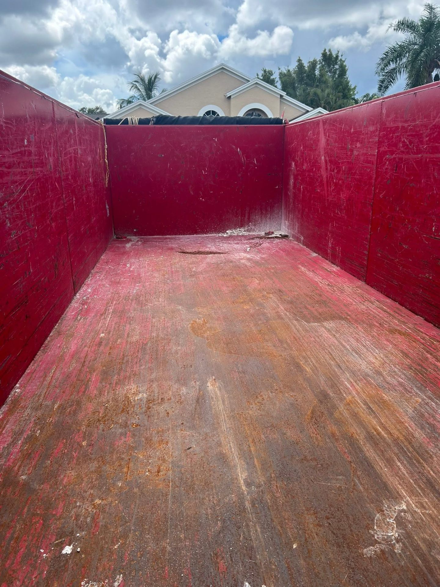Empty interior of a 17-yard dump trailer with a walk-in rear gate.