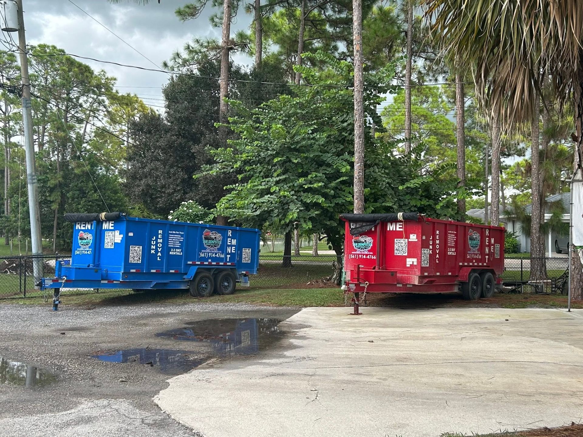 Two red 17-yard dump trailers from T & R Dumpster Rentals.